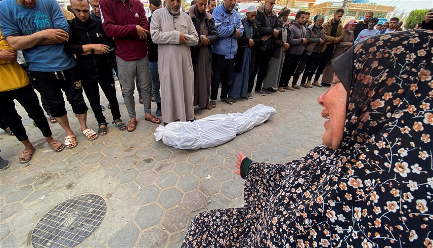 فلسطينيون يصلون على أحد ضحايا الحرب في غزة بينما تبكي أمه بحرقة (وكالات)