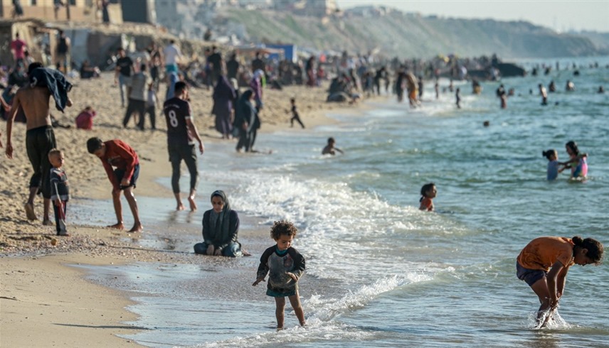 آلاف الفلسطينيين النازحين يصلون إلى شاطئ دير البلح وسط قطاع غزة (أ ف ب)