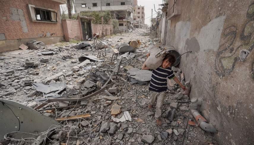 طفل فلسطيني يمشي على الأنقاض وسط غزة.