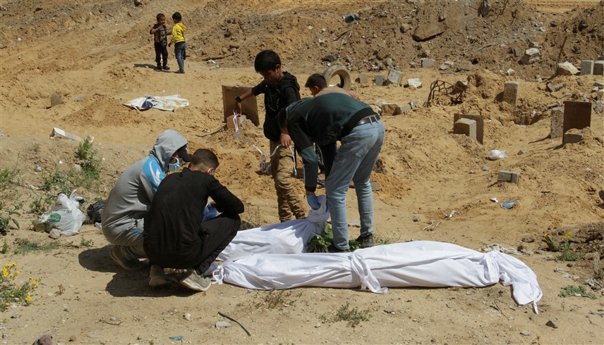 مدنيون يحاولون دفن قتلى في قطاع غزة (رويترز)
