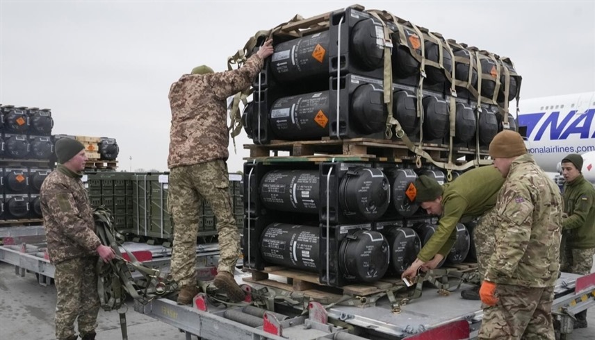 جنود أوكرانيون يفرغون شحنة أسلحة أمريكية في كييف (أ ب)