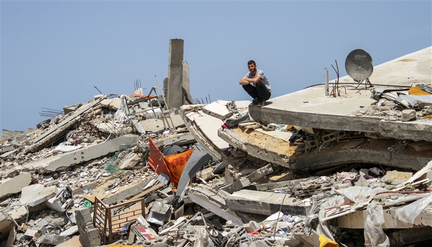 فلسطيني على أنقاض منزل في غزة بعد قصف إسرائيلي (رويترز)