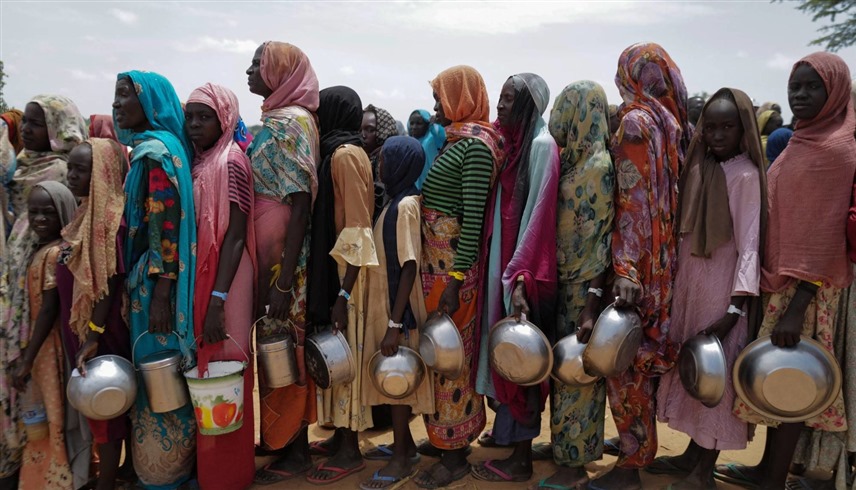 سودانيات ينتظرن الحصول على الطعام (رويترز)