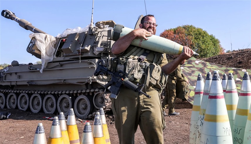 جندي إسرائيلي يحمل قذيفة مدفعية قرب الحدود اللبنانية (أرشيف)