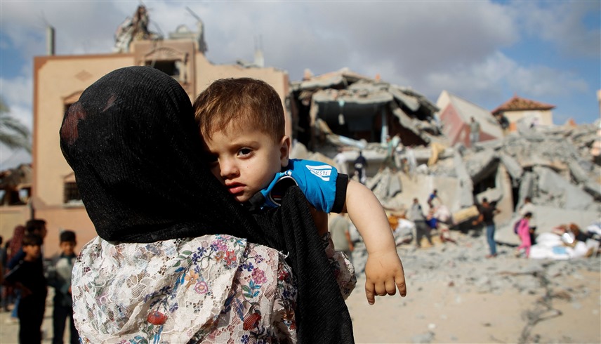 فلسطينية مع طفلها في غزة وسط الأنقاض (أرشيف)