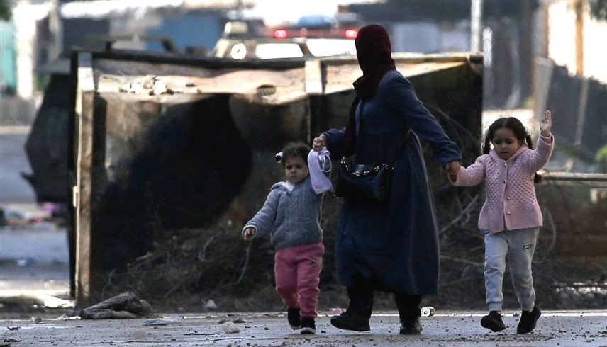فلسطينية مع طفلين في رفح (رويترز)