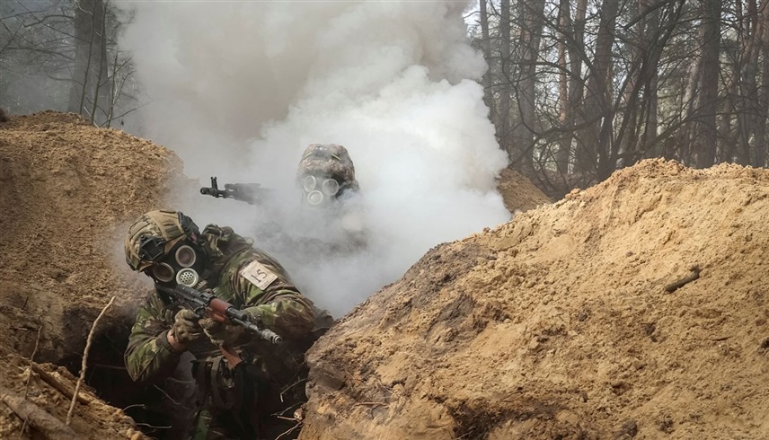 جنود أوكرانيون يضعون الأقنعة في خندق (أ.ب)