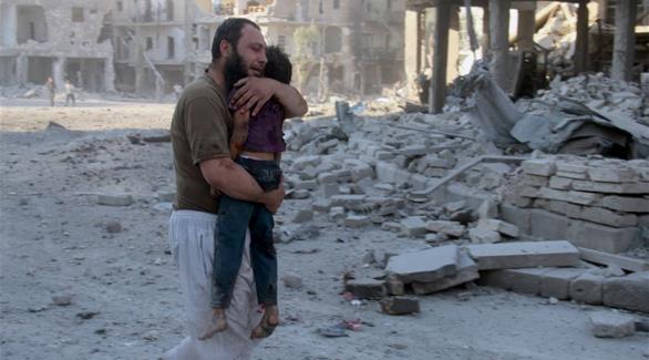 أحد سكان حلب يحمل طفله بعد إصابته جراء قصف النظام (أرشيف)