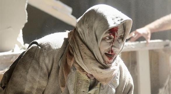 جريحة سورية تحاول الخروج من ركام القصف على مناطق مختلفة في حلب (رويترز)