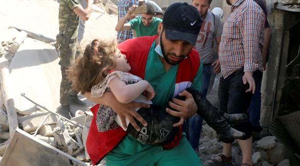 عامل إنقاذ يساعد طفلة بين ركام الغارات على حلب (رويترز)