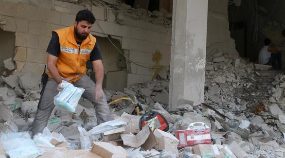 عامل إغاثة يتفقد المستلزمات الطبية المتناثرة بعد غارة استهدفت مستودعاً طبياً بحي طارق في حلب (رويترز)