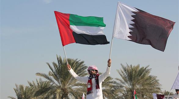 شاب يحمل العلم القطري والإماراتي 