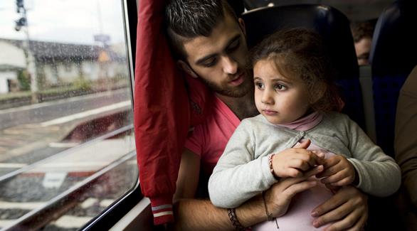 لاجئ سوري مع ابنته (أرشيف)