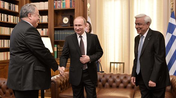الرئيس الروسي مصافحاً وزير الخارجية اليوناني قبل لقاء الرئيس (أ ف ب)