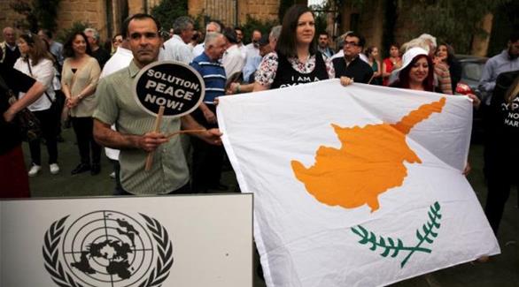 متظاهرون يحملون العلم القبرصي وشعار الأمم المتحدة(أرشيف - رويترز)