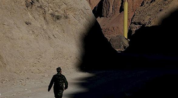 جندي إيراني يمشي بالقرب من موقع تجريب صاروخ(رويترز)