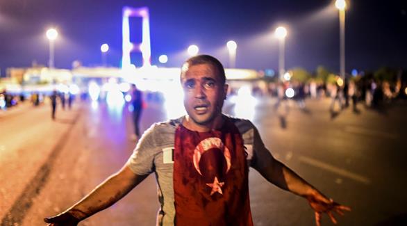 رجل مغطى بالدماء يقف امام جسر البوسفور في اسطنبول (غيتي)