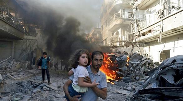 أب سوري يحاول إنقاذ ابنته بعد غارات في حلب (أرشيف) 