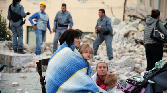 ناجون وسط ركام بيتهم الذي دمر في الزلزال بأمتريتشي أحد المناطق الأكثر تضرراً (أ ف ب)