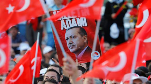 مناصرون للرئيس التركي يحملون صورة له في إحدى التجمعات (أرشيف)