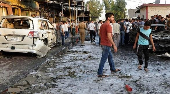 عراقيون في مكان تفجير انتحاري سابق في منطقة الإسكان (أرشيف)