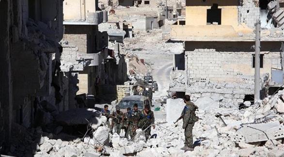 جنود من الجيش السوري وسط أنقاض مخيم حندرات في مدينة حلب (أرشيف)