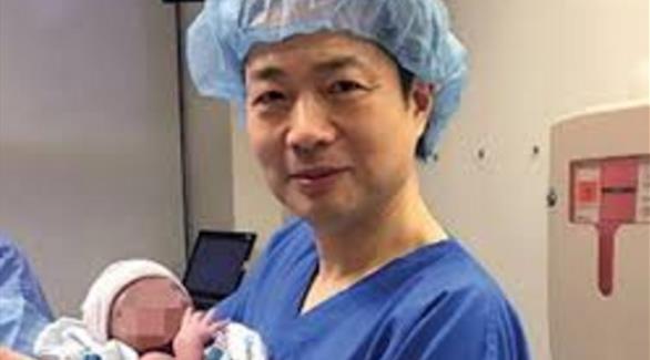 الدكتور جون تشانغ يحمل الطفل (ديلي ستار)