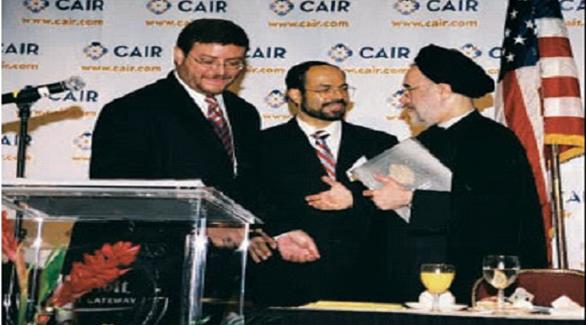 أحمد الأخرص يسار الصورة مصافحاً الرئيس الإيراني السابق محمد خاتمي في لقاء نظمه مركز "كير" (أرشيف)