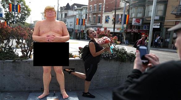 أحد المارة تلتقط صورة مع تمثال ترامب(غيتي)