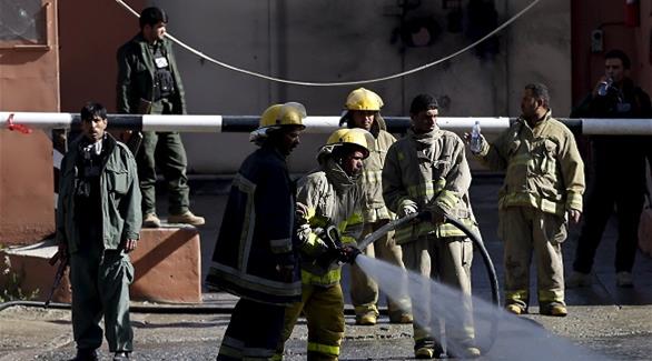 رجال أطفاء أفغان يخمدون الحريق في مكان الهجوم (رويترز)