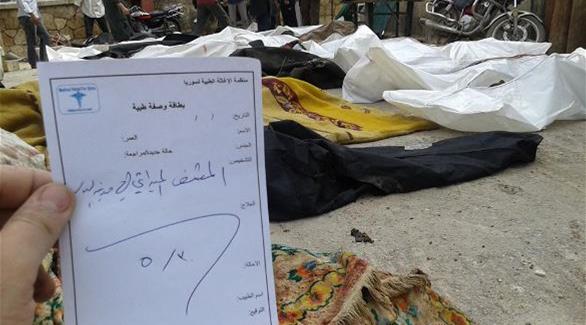 بطاقة من "منظمة الإغاثة الطبية السورية" والجثث في الخلفية (مراسل سوري)