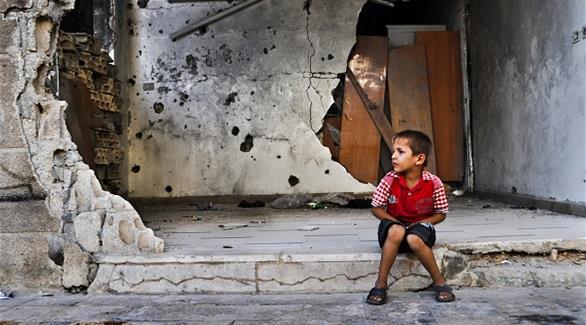 طفل سوري أمام منزل مدمر في حمص (أرشيف)