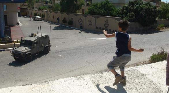 طفل فلسطيني يرشق جنود الاحتلال بالحجارة (أرشيف)