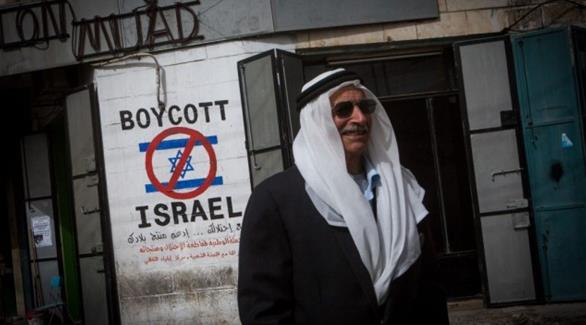 رجل يمر أمام رسم يدعو إلى مقاطعة إسرائيل في مدينة بيت لحم (أرشيف)