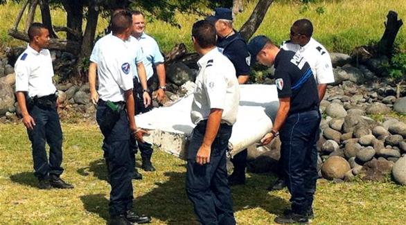 الشرطة تحمل حطام الجناح الذي عثر عليه الاسبوع الماضي في المحيط الهندي(غيتي)
