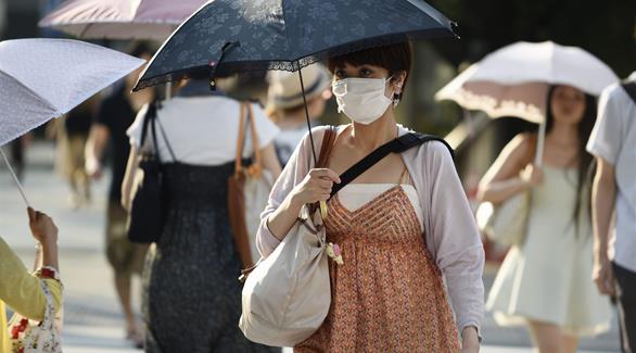 يابانيون يحملون المظلات للحماية من لهيب الشمس (إفي)