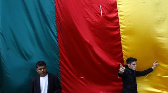 أكراد يلتقطون صورة أمام علم حزب العمال الكردستاني(رويترز)