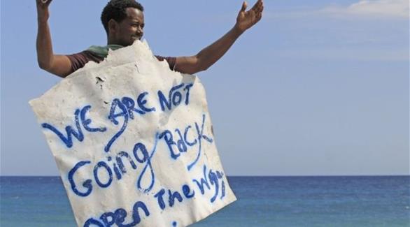 لاجئ يحمل يافطة كتب عليها "لن نعود..افتحوا الطريق"