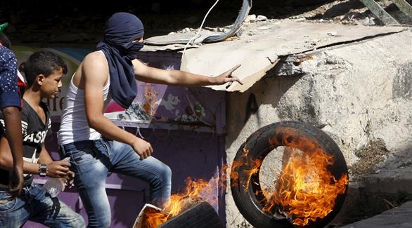 رمي دولاب مشتعل تجاه جيش الاحتلال الاسرائيلي (رويترز)