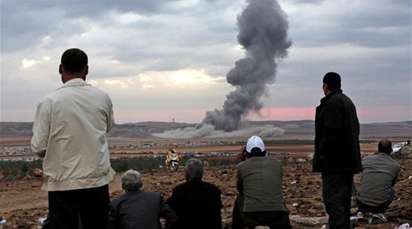 سكان يراقبون قصفاً لقوات التحالف على إرهابيي داعش في أكتوبر 2014(إ ب أ)