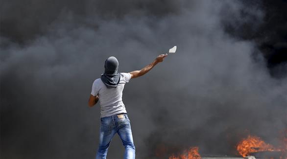 فلسطيني يقاوم ضد الجيش الإسرائيلي (رويترز)