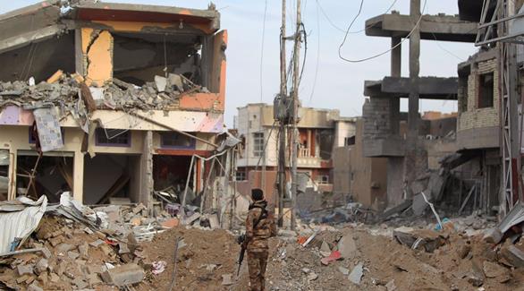 جندي عراقي يقف أمام المبان المدمرة من قبل داعش(أرشيف)