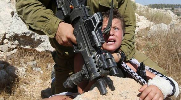 جندي إسرائيلي يعتقل فتى فلسطينياً(أ ف ب)