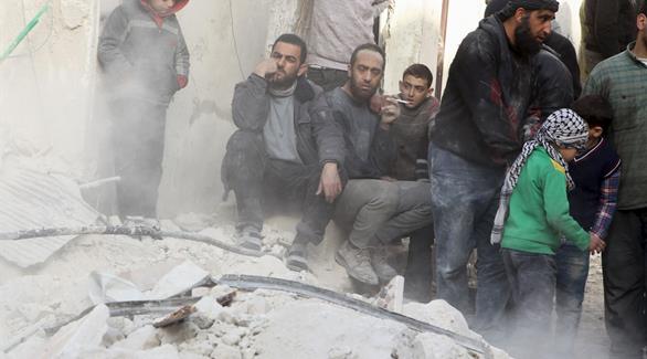 سوريون يجلسون على حطام منزلهم في حلب بعد ضربات جوية شنتها مقاتلات النظام (رويترز)