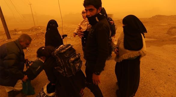 نازحون من الموصل يصلون قرية غوغجلي أثناء هبوب عاصفة رملية أمس الجمعة (أ ف ب)