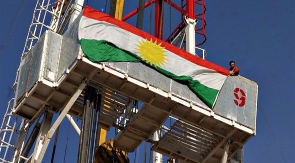 كردي يرفع علم كردستان العراق على منشأة نفطية (أرشيف)