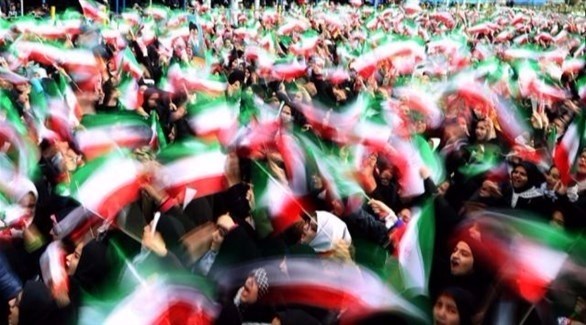 تلامذة إيرانيون  يرفعون أعلاماً إيرانية.(أرشيف)