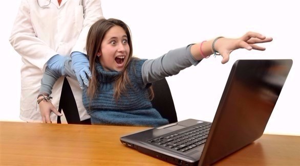 شابة تحاول الوصول إلى كمبيوتر محمول (أرشيف)