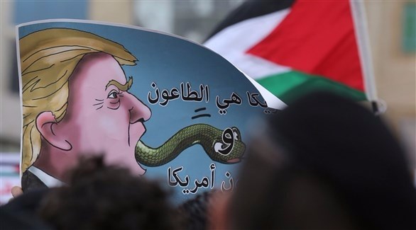 صور مرفوعة للرئيس الأمريكي أمام السفارة الأمريكية في عمان (أ ف ب)