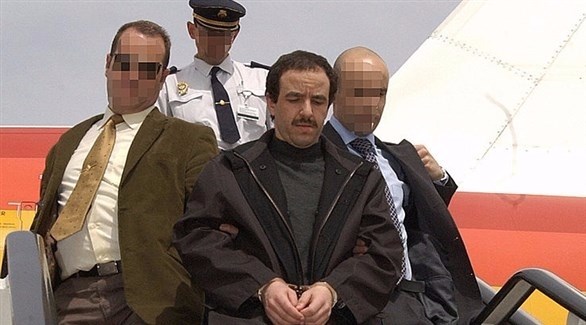 الشرطة الأسبانية تقتاد بلحاج خارج الطائرة بعد توقيفه في بلجيكا (أرشيف / غيتي)